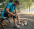 Runner applying gel knee pad on park bench